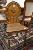 A Victorian oak hall chair.
