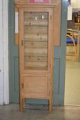 A pine floor standing two door display cabinet.