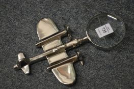 A novelty magnifying glass with aeroplane handle.