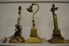 Three brass table lamps.