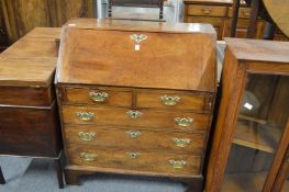 A George III mahogany bureau with brass handles and escutcheons.