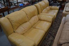 A pair of tan leather upholstered two seater settees.