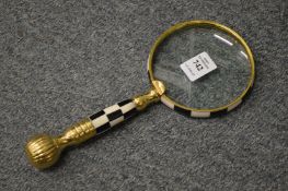 A magnifying glass with chequered handle.