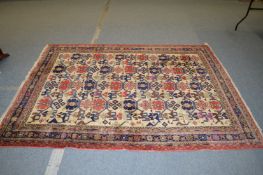 A Persian carpet, cream ground with stylized motifs.