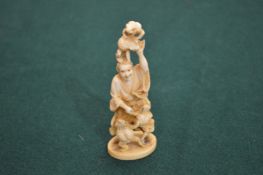 A Japanese ivory okimono of a man and frogs.