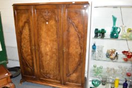 A walnut three door wardrobe.