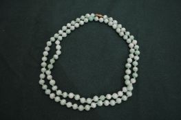 A pale green jade bead necklace.