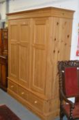 A good modern pine three door wardrobe with three drawers to the base.