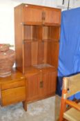 A stylish teak display unit with cupboard doors.