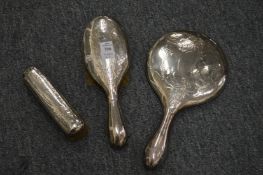 A three piece silver backed dressing table set to include a hand mirror.