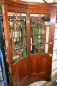 An unusual mahogany curving half glazed door.
