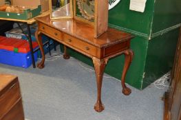 A Georgian style mahogany two drawer side table on carved cabriole legs with claw and ball feet.