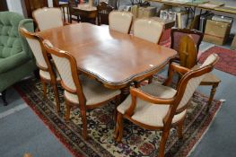 A French style extending dining table with a set of six matching chairs, two with arms.