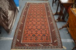 A Persian carpet, rust ground with geometric design.