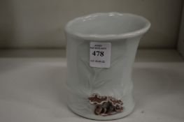 A Chinese porcelain brush pot moulded as a bamboo stem.