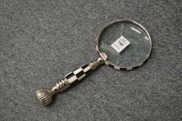 A magnifying glass with chequered handle.