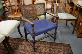 A mahogany armchair with canework back, over-stuffed seat and bobbin turned stretchers and legs.
