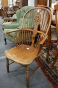 A 19th century ash, yew and elm wheel back Windsor armchair.