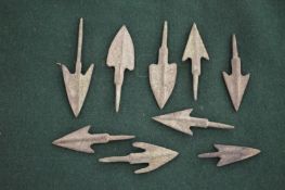 Nine small metal arrowheads, various sizes.