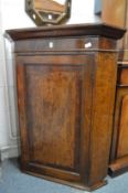 A 19th century oak and mahogany hanging corner cupboard.