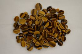 A box of unmounted tiger's eye cabochon stones.