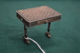 A miniature filigree silver table.
