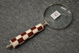 A magnifying glass with chequered handle.