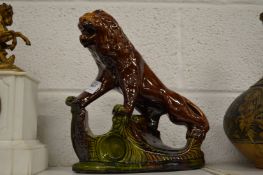 A treacle glazed pottery model of a lion.