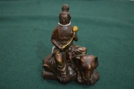 A Thai bronze Buddha seated on an elephant.
