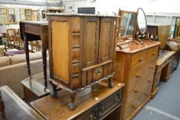 A continental small hardwood two door cabinet on claw and ball feet.