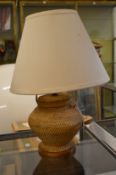 A wickerwork table lamp.