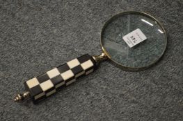 A magnifying glass with chequered handle.