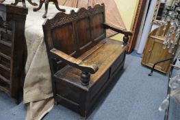A carved oak monk's bench.