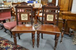 A pair of Victorian mahogany hall chairs with tile inset back panel.
