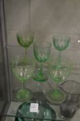 Two etched pale green glass wine glasses and three other glasses.