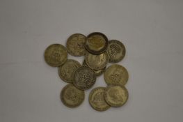 A quantity of shillings dating from the first half of the 20th century.