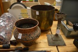 An eastern embossed copper pot, an engraved brass pot and a candle stand.