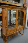 The upper section of a late Victorian satinwood cupboard bookcase with two glazed doors and two