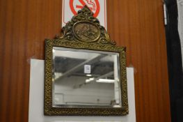 Decorative embossed brass framed mirror.