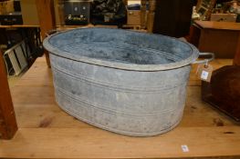 A large galvanized oval planter, a galvanized bath and a grain measure.