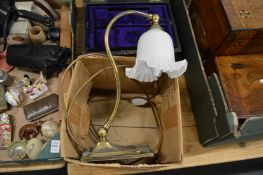 A brass desk lamp with opaque glass shades.