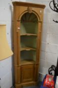 A classical style pine standing corner cabinet with barrel back and cupboard door to the base.