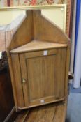A pine hanging corner cupboard.
