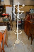 A cream painted wrought iron coat rack / umbrella stand.