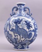 A LATE 19TH CENTURY BLUE AND WHITE TWIN HANDLE PORCELAIN MOON FLASK, the centre painted with kylin