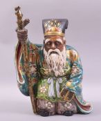 A JAPANESE KUTANI PORCELAIN FIGURE OF AN ELDERLY SAGE, standing with a staff in his right hand, 30cm
