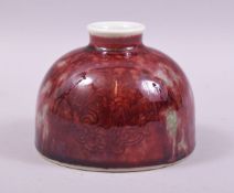 A CHINESE RED GLAZED PORCELAIN INKWELL / VASE, base with six character mark, 12cm diameter.