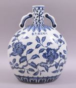 A CHINESE BLUE AND WHITE PORCELAIN TWIN HANDLE MOON FLASK, the body painted with flora, with six