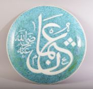 A CIRCULAR GREEN GLAZED CALLIGRAPHIC MOSQUE PLATE, 33cm diameter.