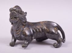 A CHINESE CAST METAL FIGURE OF A BEAST / FOO DOG, with speckled gilt to body, 11cm long.